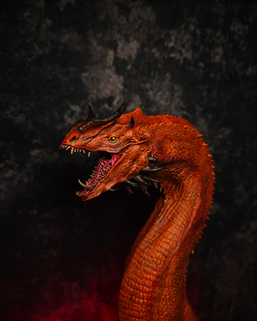 Buste de dragon rouge inspiré de Caraxes avec gueule ouverte et long cou écailleux, peint à la main et présenté sur un socle bronze dans une ambiance fantasy sombre.