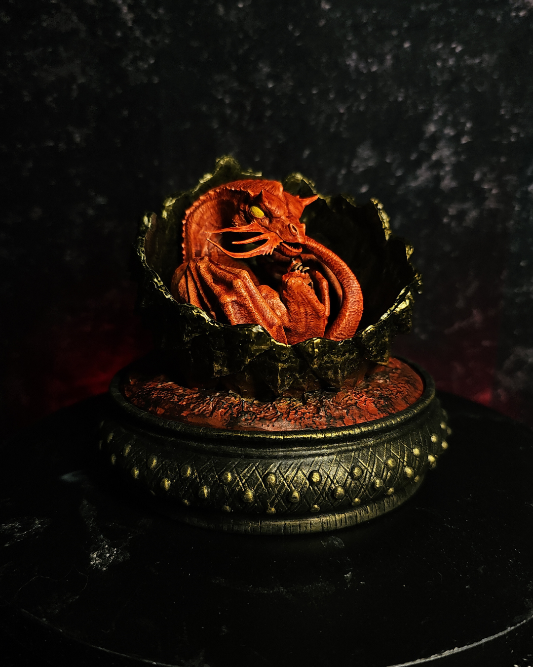 Fantasy resin baby dragon inspired by Caraxes from House of the Dragon resting inside a volcanic dragon egg display