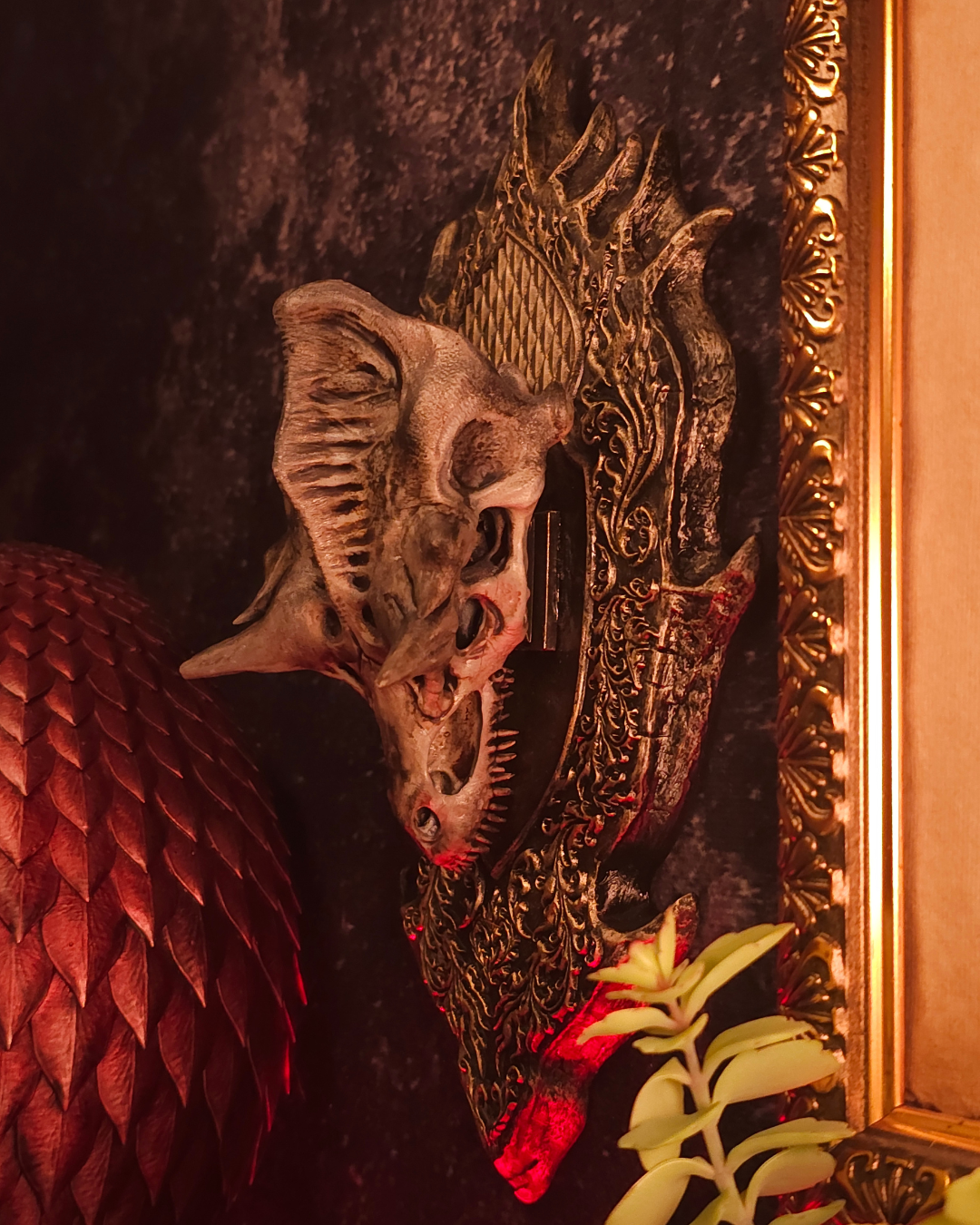 Crâne de dragon stylisé vu de côté, avec textures osseuses réalistes et support sculpté, éclairage rouge et ambiance gothique fantasy.