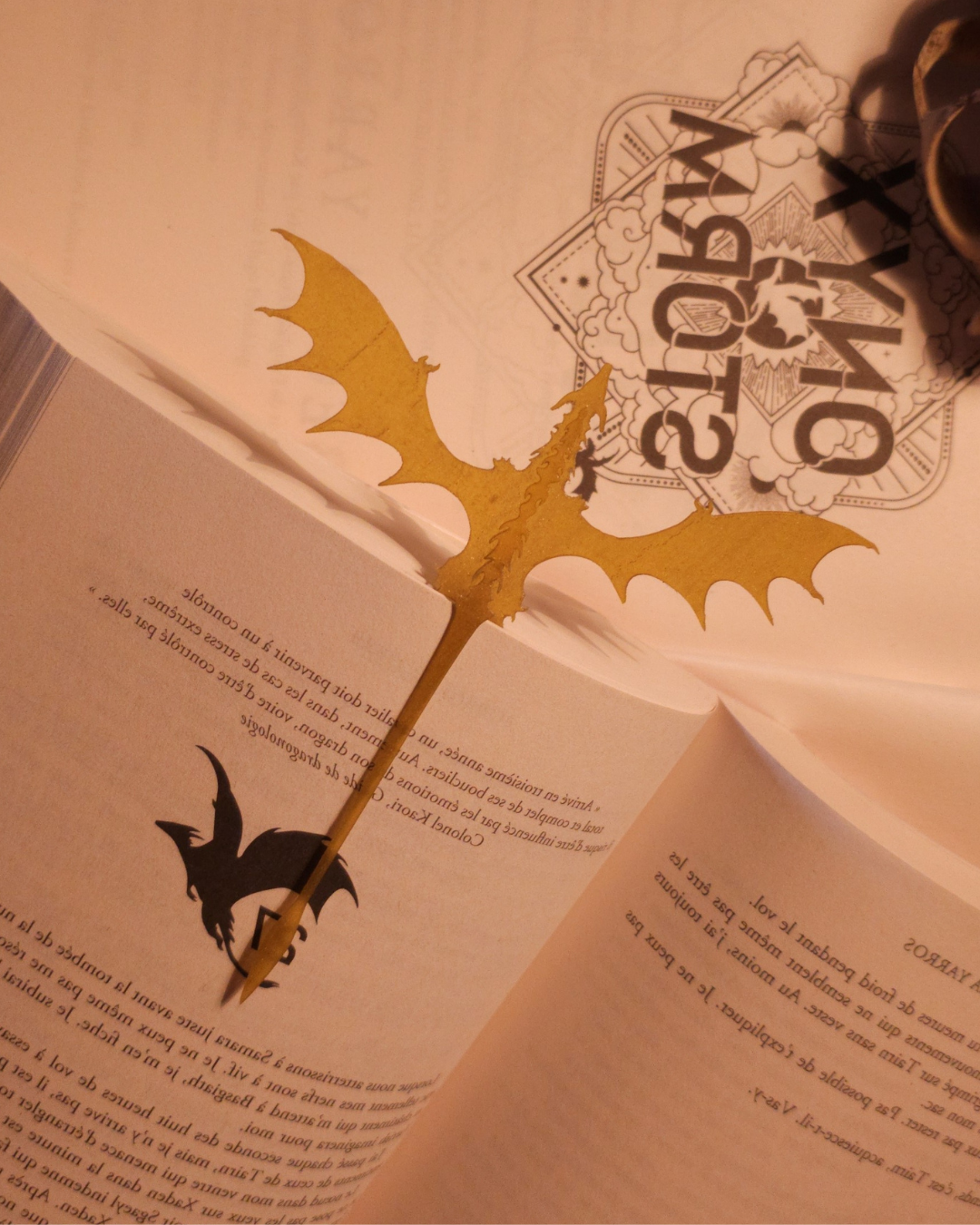 Gros plan sur la base du dragon doré Gold Feathertail, montrant la précision de l’impression 3D et les détails inspirés de la figurine de dragon Andarna. La résine pailletée renforce son aspect magique et précieux.