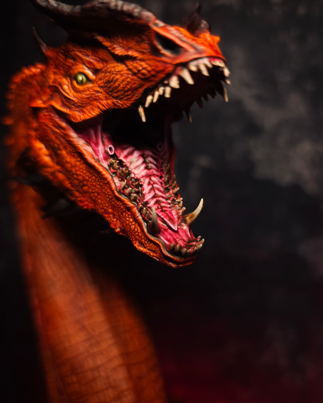 Gros plan de la gueule ouverte d’un dragon rouge montrant les dents, les défenses, la langue et les détails peints à la main pour un rendu réaliste.