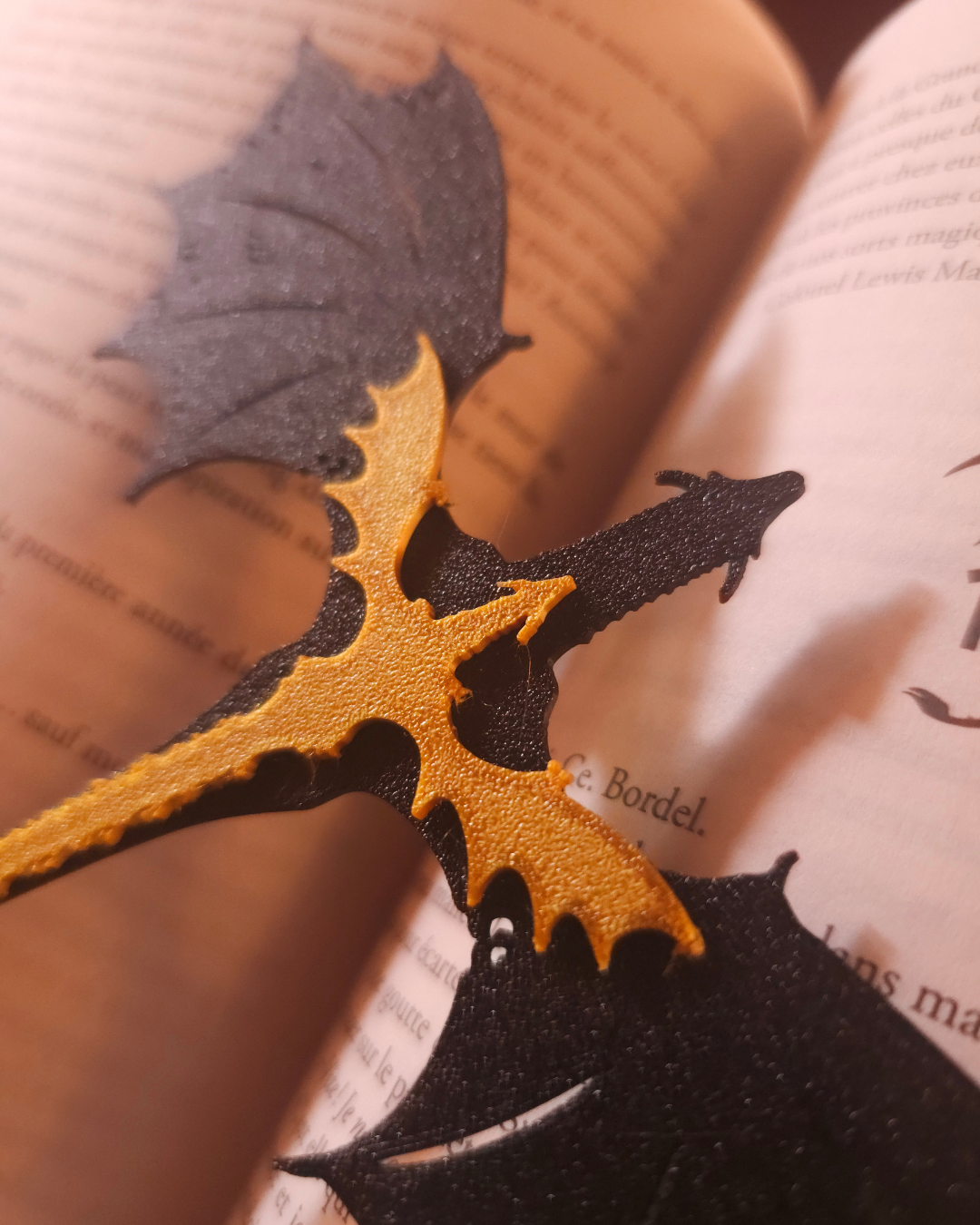 Gros plan sur la tête et les ailes du marque-page dragon imprimé en 3D inspiré de Tairn et Andarna de la saga Fourth Wing.
