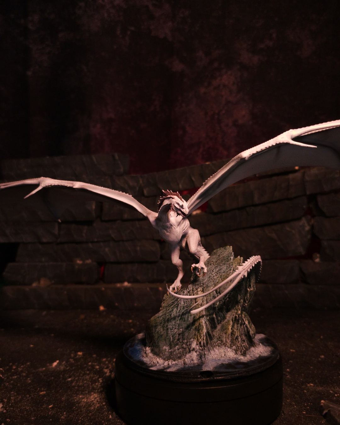 Figurine complète du dragon Greyghost sur son socle rocheux avec ailes déployées.