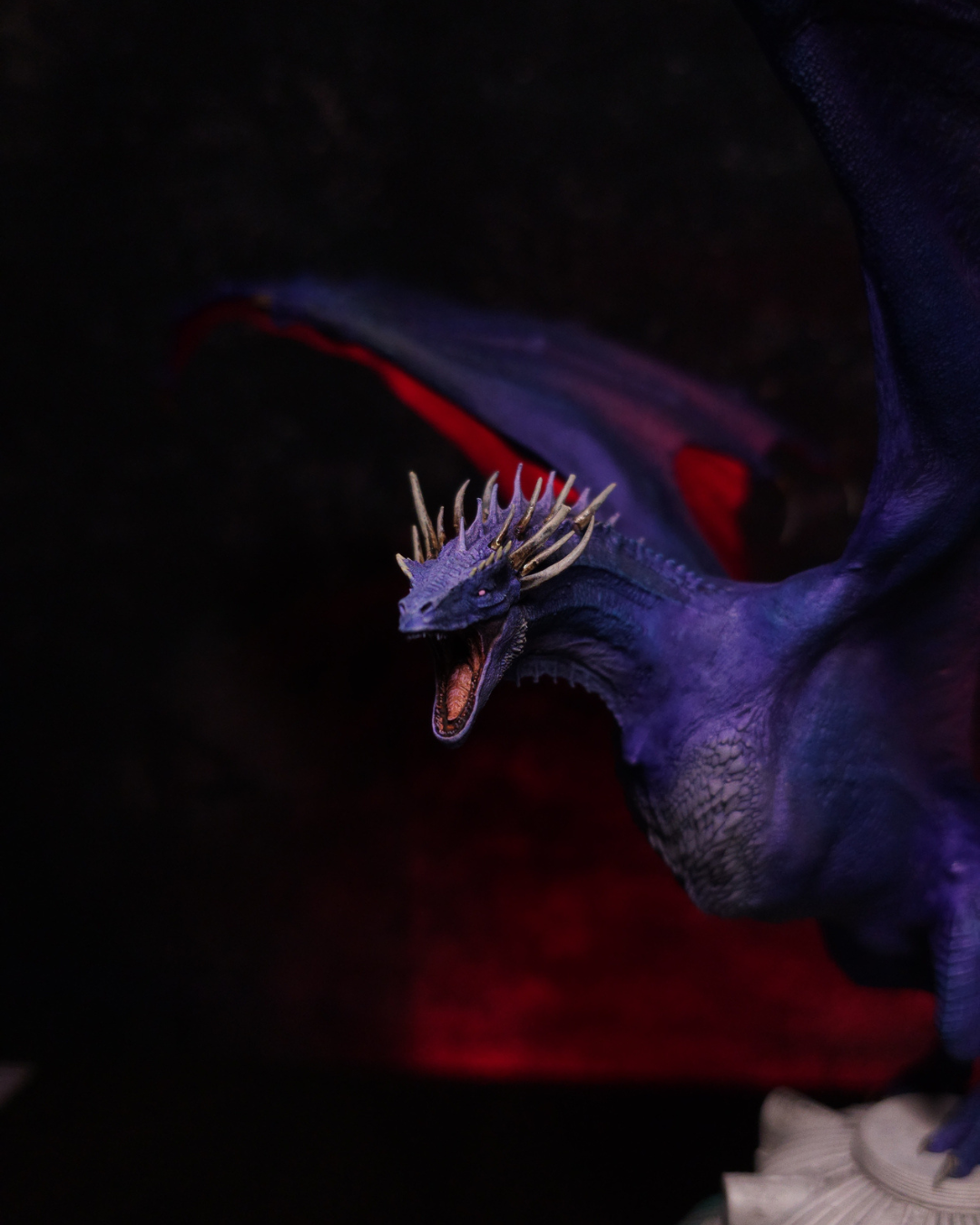 Gros plan sur la figurine Dreamfyre de HOTD, dragon violet aux ailes rouges et aux cornes dorées, avec une sculpture détaillée du cou et du poitrail.