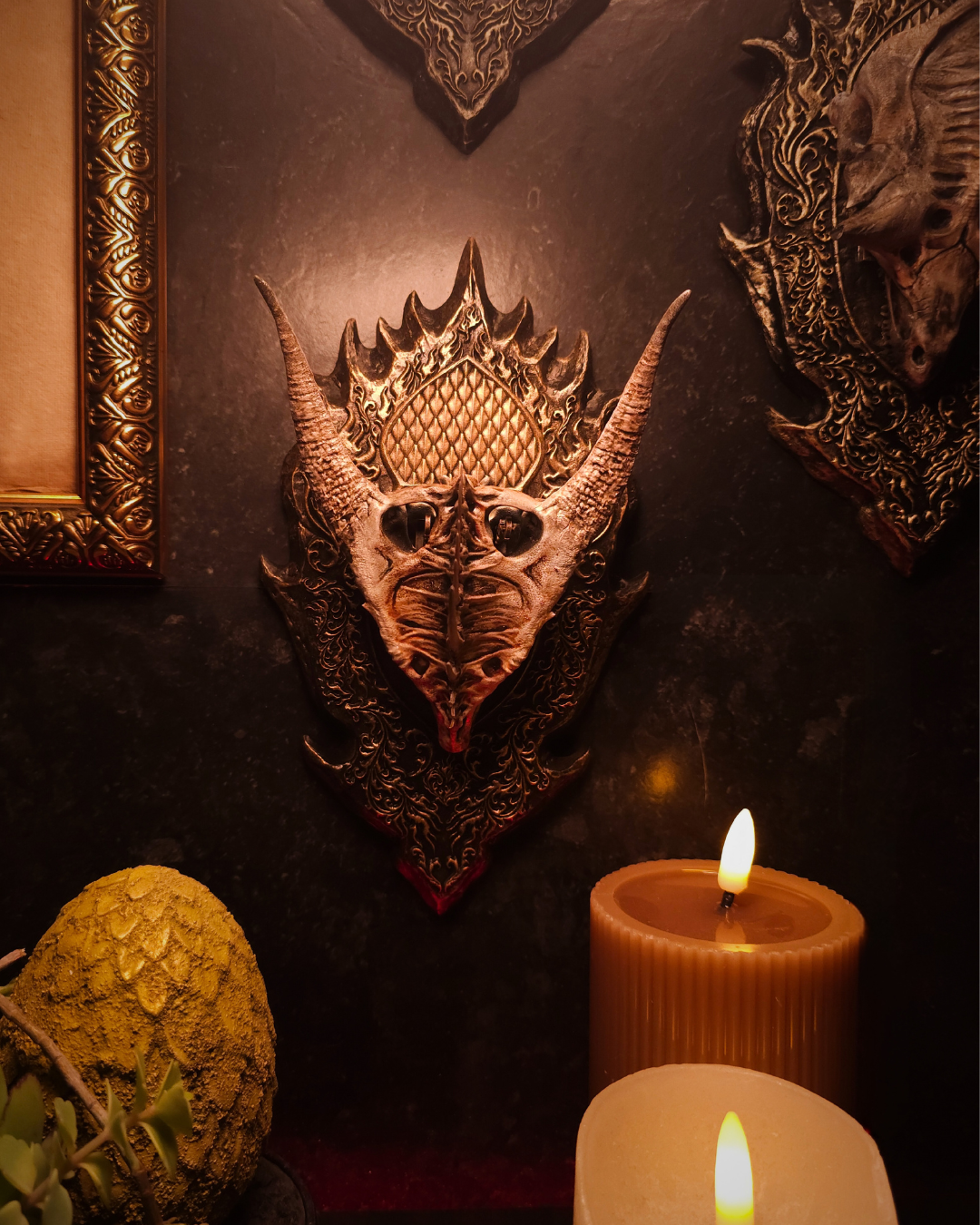 Trophée mural représentant un crâne de dragon Moondancer, entouré de bougies et d’éléments décoratifs, créant une scène de fantasy décor gothique.