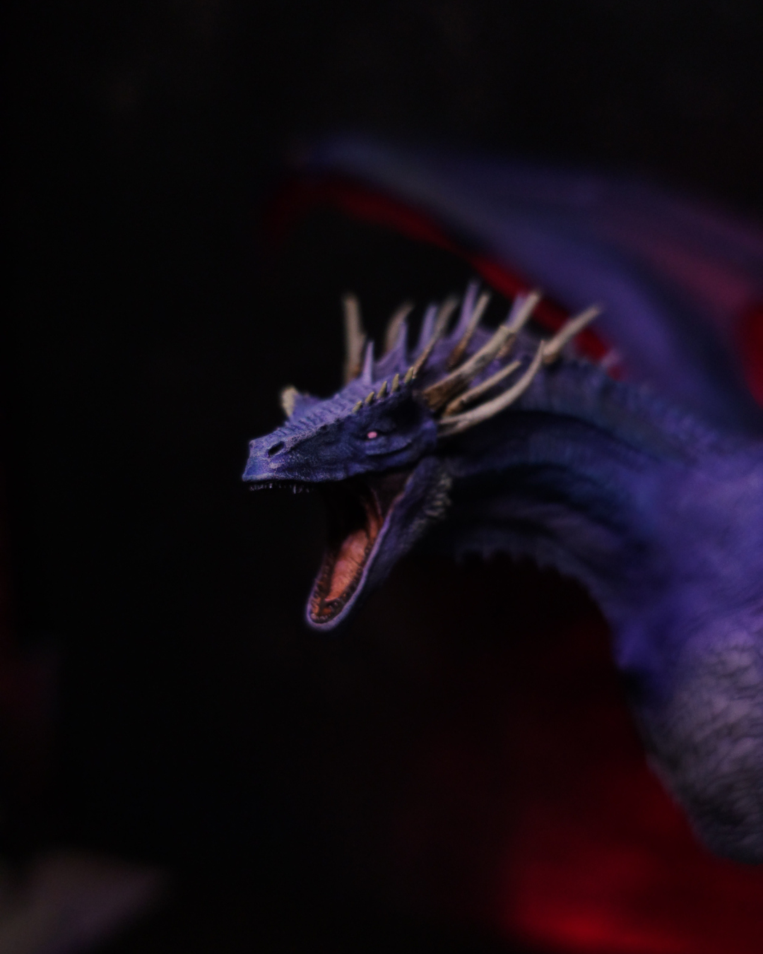 Détail du profil de Dreamfyre, figurine de dragon Targaryen en résine peinte à la main, montrant ses cornes dorées, son œil rose et ses écailles violettes.