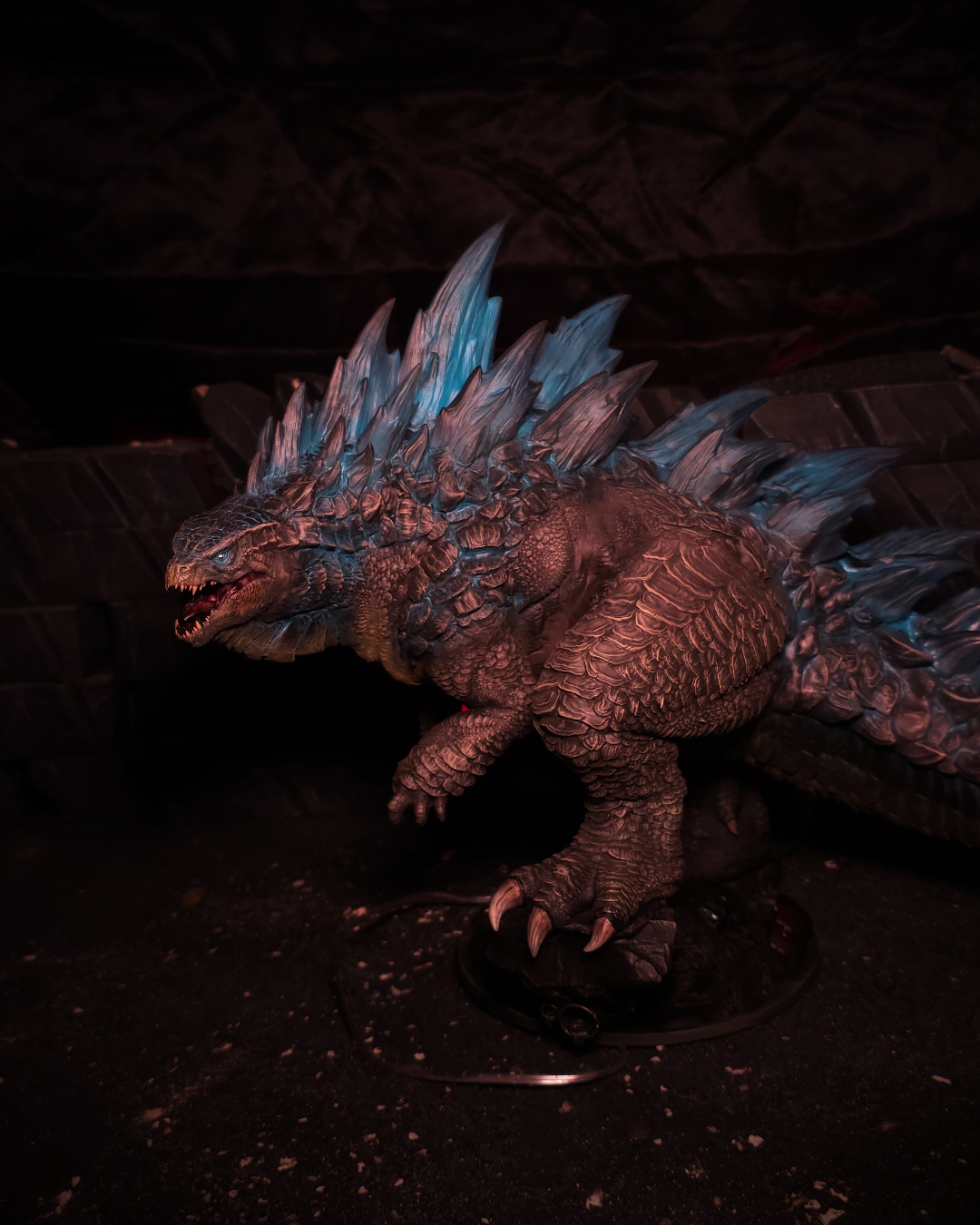 Profil du King of Monsters avec gueule ouverte, éclairage rouge en arrière-plan et crêtes bleutées visibles, collectible figurine parfaite pour fantasy décor sombre.