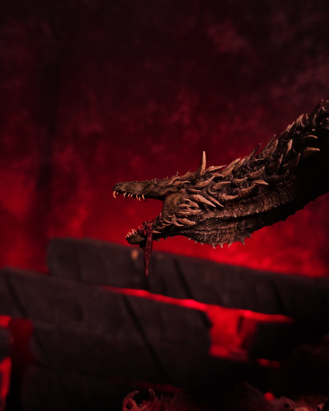 Vue de profil du dragon Sheepstealer, crocs apparents et regard féroce, dans une ambiance rouge infernale inspirée de House of the Dragon.