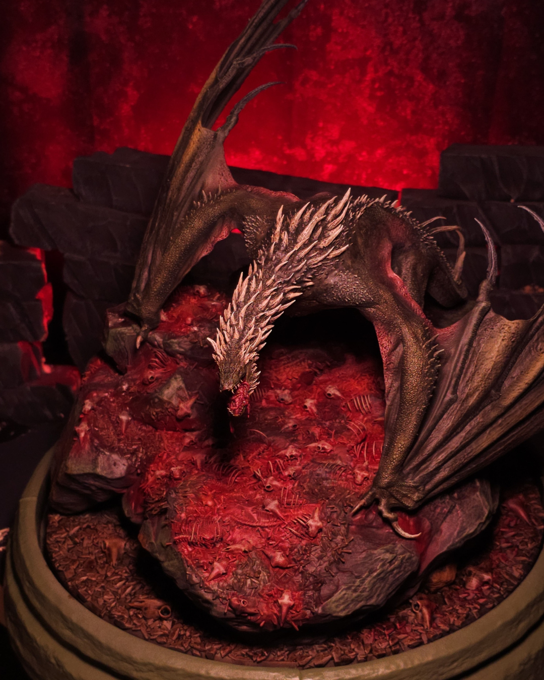 Le dragon Sheepstealer rugissant au-dessus d’un amas d’ossements et de crânes, lumière rouge intense pour un effet dramatique et horrifique.
