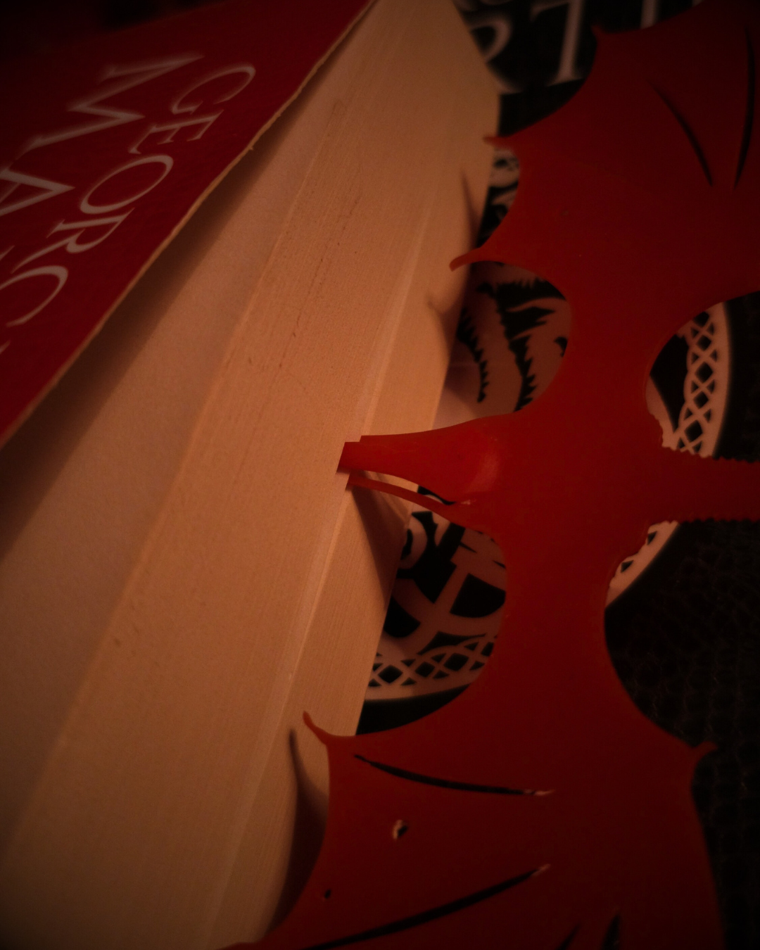 Marque-page en résine rouge Meleys, glissé à l’intérieur d’un livre de fantasy, inspiré de la saga Game of Thrones.