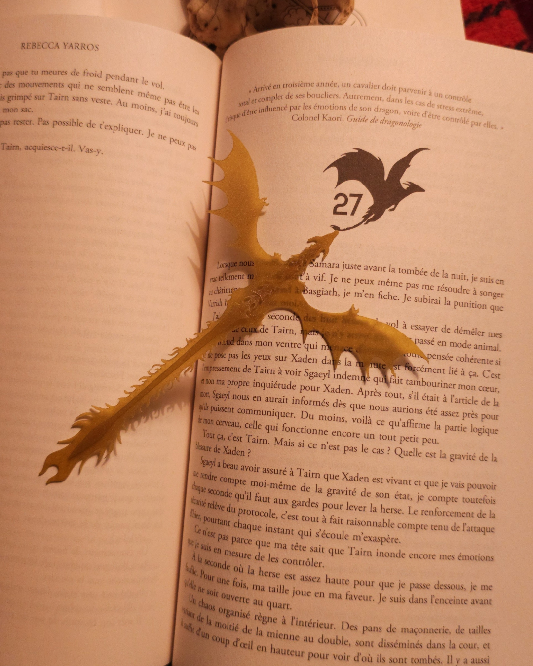 Photo du marque-page dragon doré Gold Feathertail, inspiré du dragon Andarna de Fourth Wing. Le marque-page, imprimé en résine 3D, repose délicatement dans un roman, mettant en valeur ses ailes fines et sa queue détaillée. Un accessoire parfait pour les fans de fantasy, de dragon et de figurine de dragon.