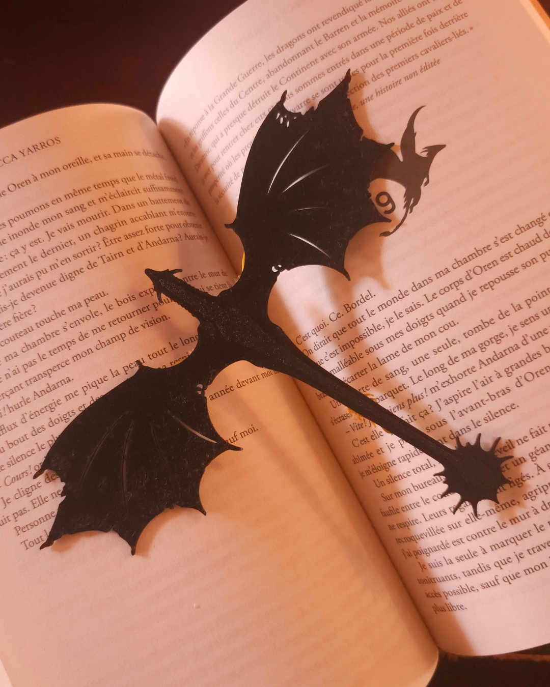 Le marque-page dragon maintient les pages d'un livre grâce à sa pince intégrée et dépasse élégamment du roman.