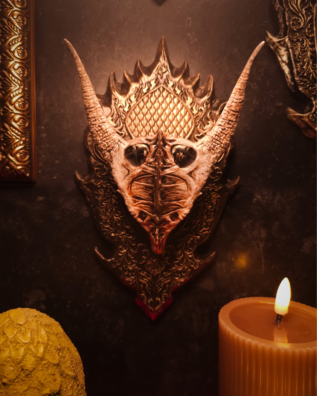 Crâne de dragon Moondancer monté en trophée mural, vu de face, avec cornes symétriques et plaque décorative sculptée d’inspiration médiévale fantasy.