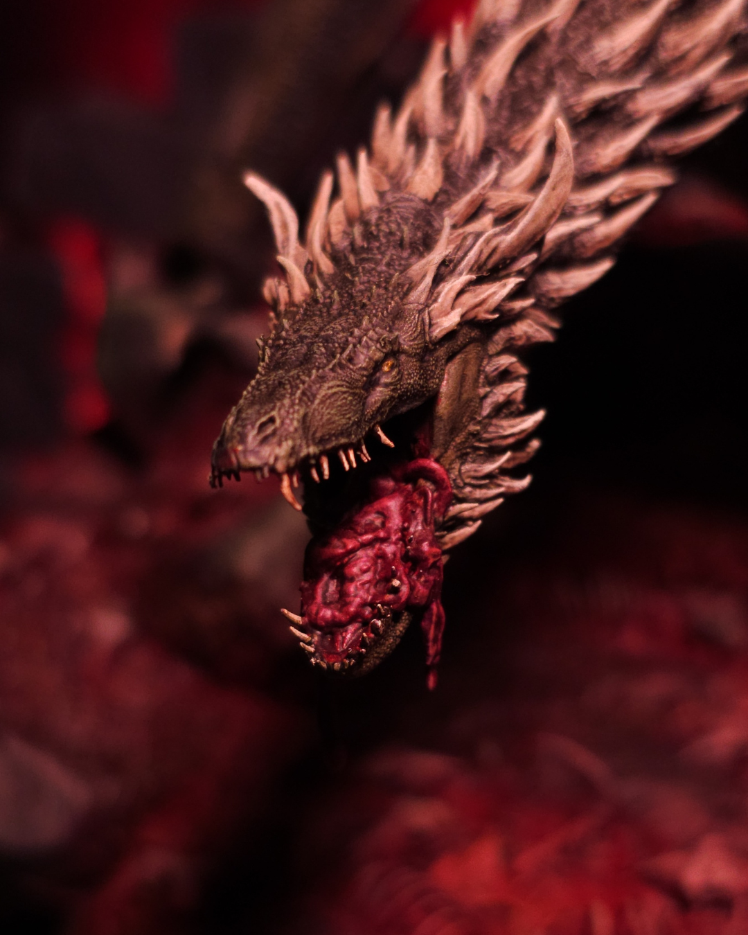 Gros plan sur la tête du dragon Sheepstealer, gueule ouverte sur un morceau de chair sanglant, textures fines et ambiance infernale digne d’un dragon légendaire.