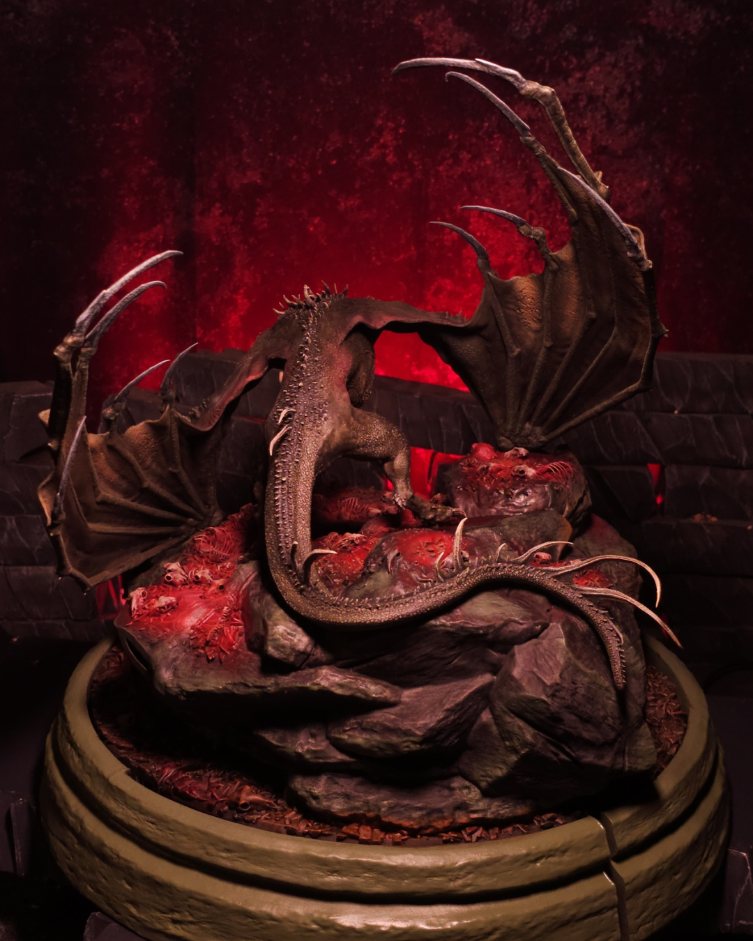 Vue arrière du dragon Sheepstealer montrant la puissance de ses ailes et la courbure de sa queue, dominant un sol couvert d’ossements dans une ambiance rouge infernale.