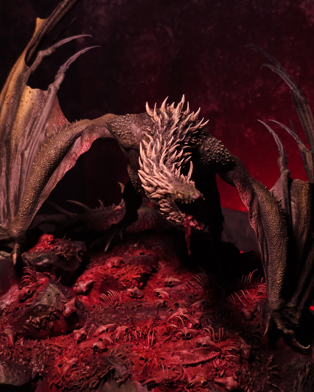 Gros plan du dragon Sheepstealer hurlant au milieu d’un champ d’ossements, ambiance sombre et teintes rougeoyantes pour une esthétique Halloween.