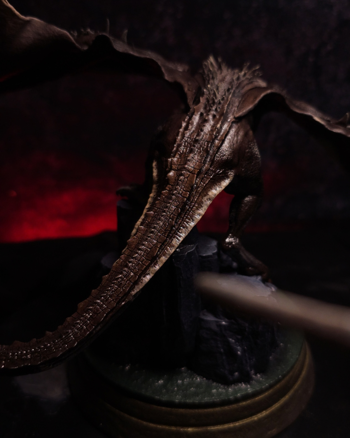 Vue arrière de la figurine Sheepstealer de House of the Dragon, présentant ses écailles brunes, sa longue queue épineuse et son socle rocheux.