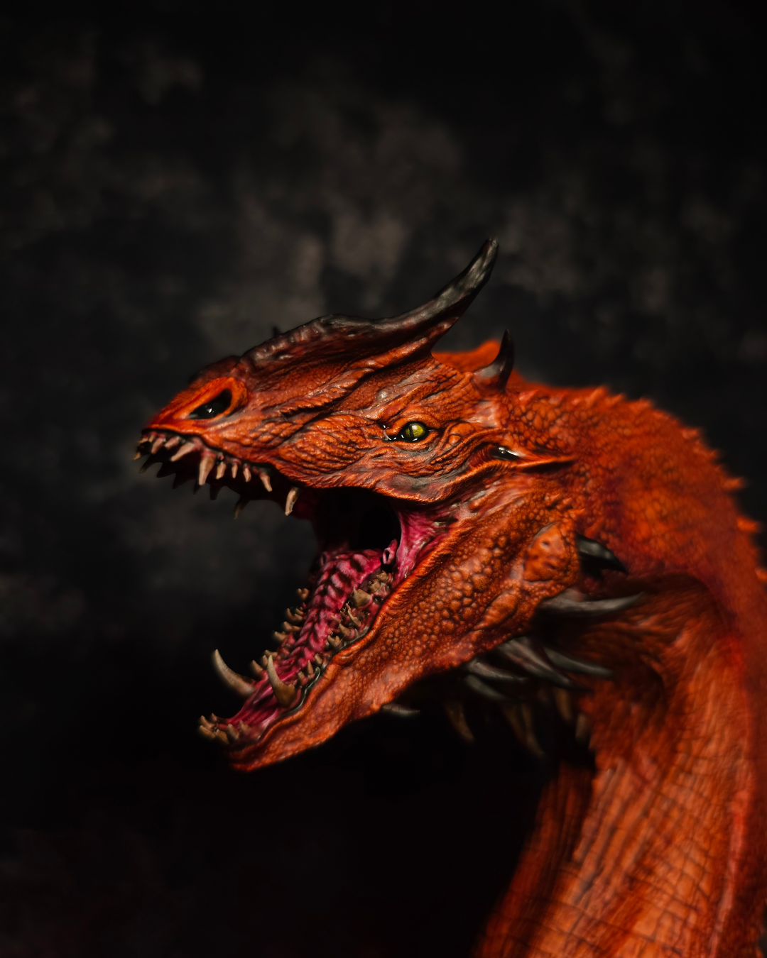 Gros plan du visage d’un dragon rouge inspiré de Caraxes montrant les écailles, les cornes, les crocs et les détails de peinture réalisés à la main.