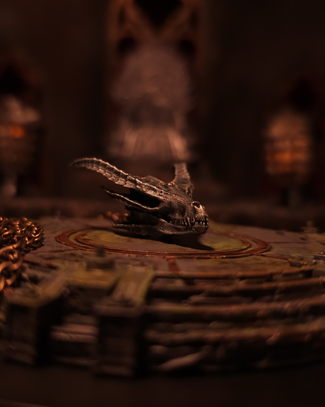 Vue de face d’un pendentif représentant le crâne argenté de Silverwing, dragon de la reine Alysanne Targaryen, posé sur un autel de pierre sous une lueur tamisée façon Donjon Rouge.