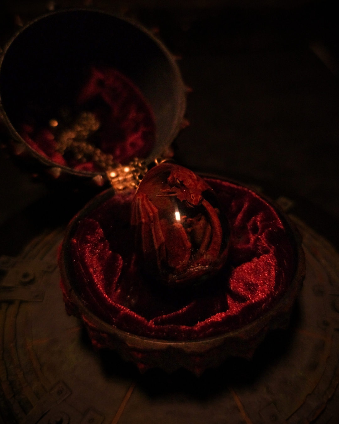 Collier artisanal The Blood Wyrm, présenté dans un écrin velours - œuf contenant un bébé dragon rouge