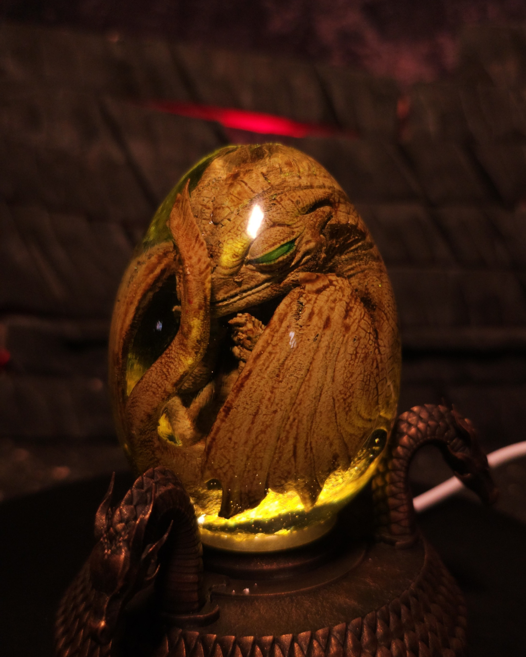 Figurine de collection représentant un embryon de dragon doré dans une capsule de résine éclairée - The Golden Mother

