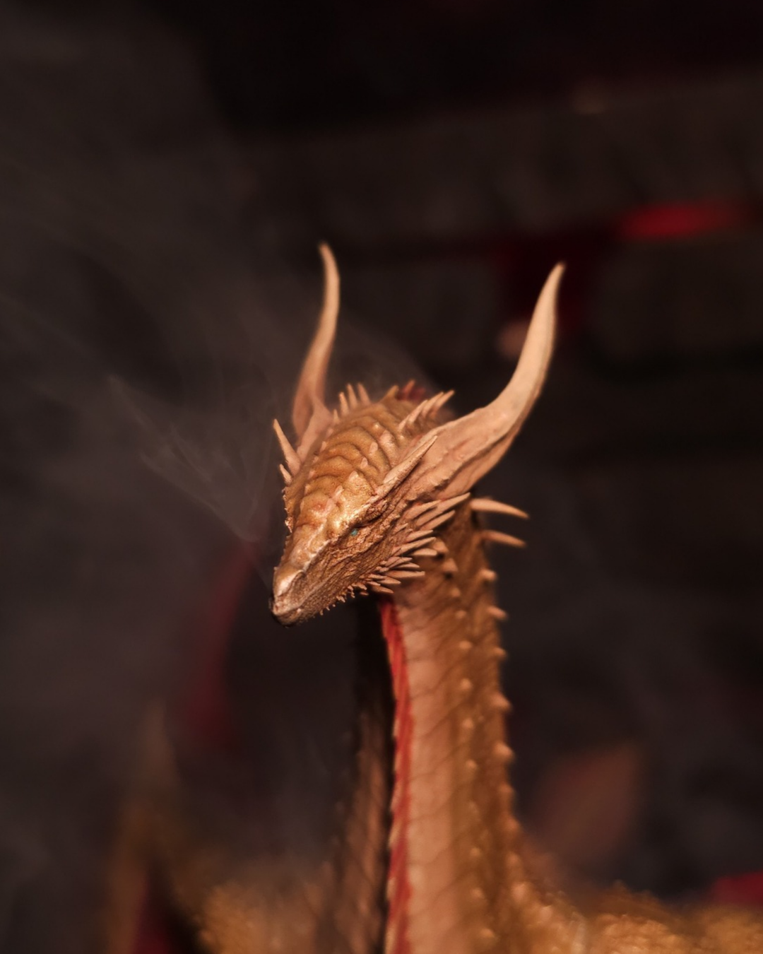 Gros plan sur la tête de Sunfyre, dragon doré de la Maison Targaryen, dévoilant ses cornes élancées et ses écailles finement sculptées, figurine résine peinte main.