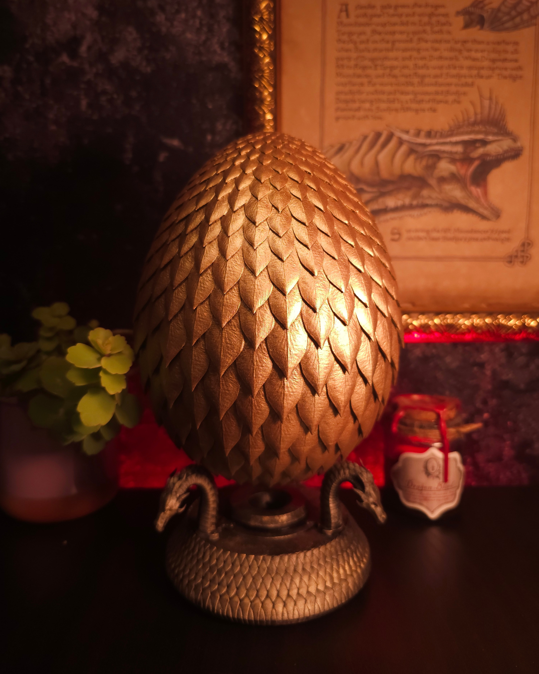 Œuf de dragon doré texturé avec écailles réalistes, posé sur un socle décoratif avec serpents, éclairage chaud rouge et ambiance fantasy immersive.